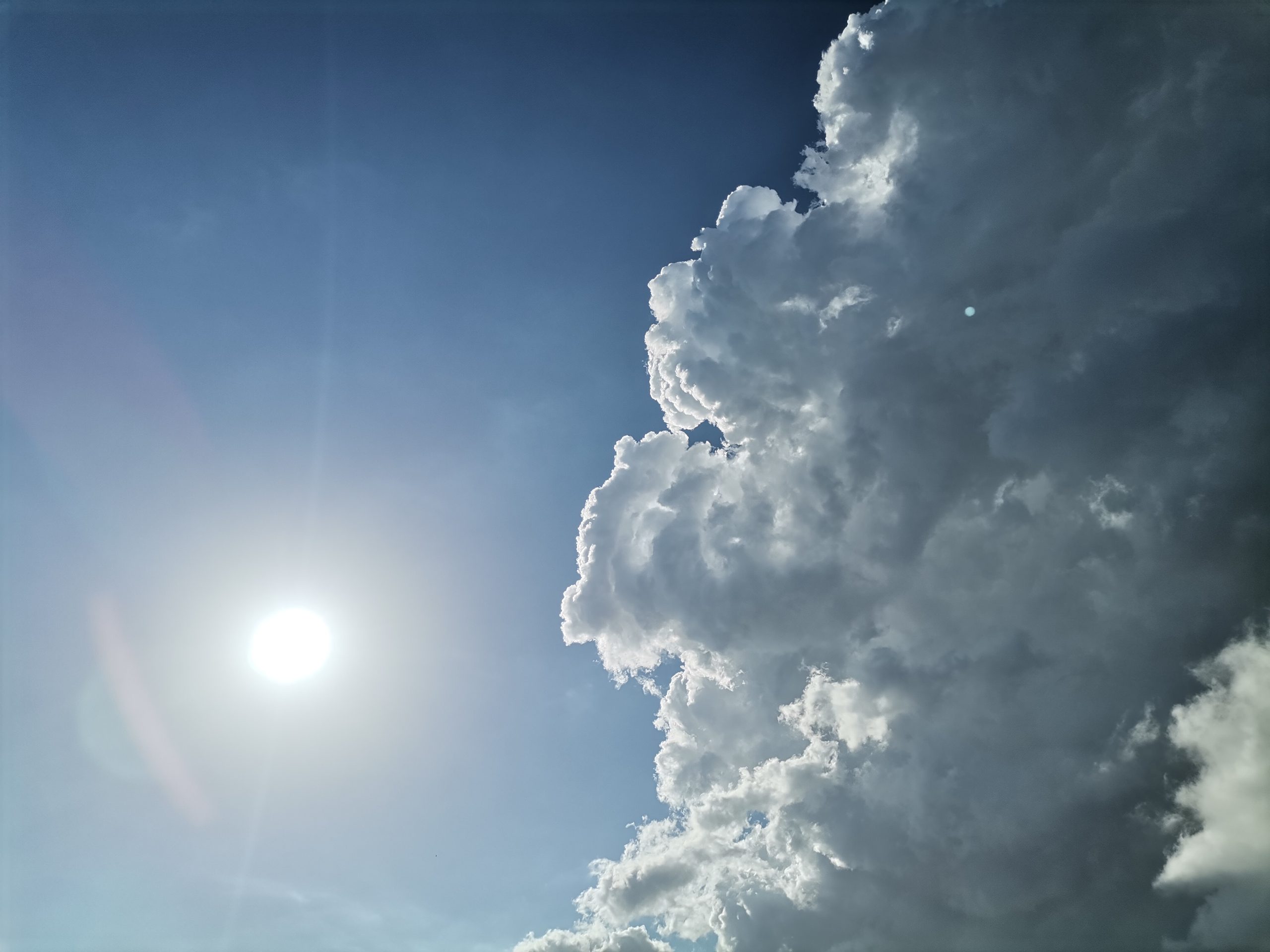 Cielo azzurro con grandi nuvole bianche illuminate dal sole
